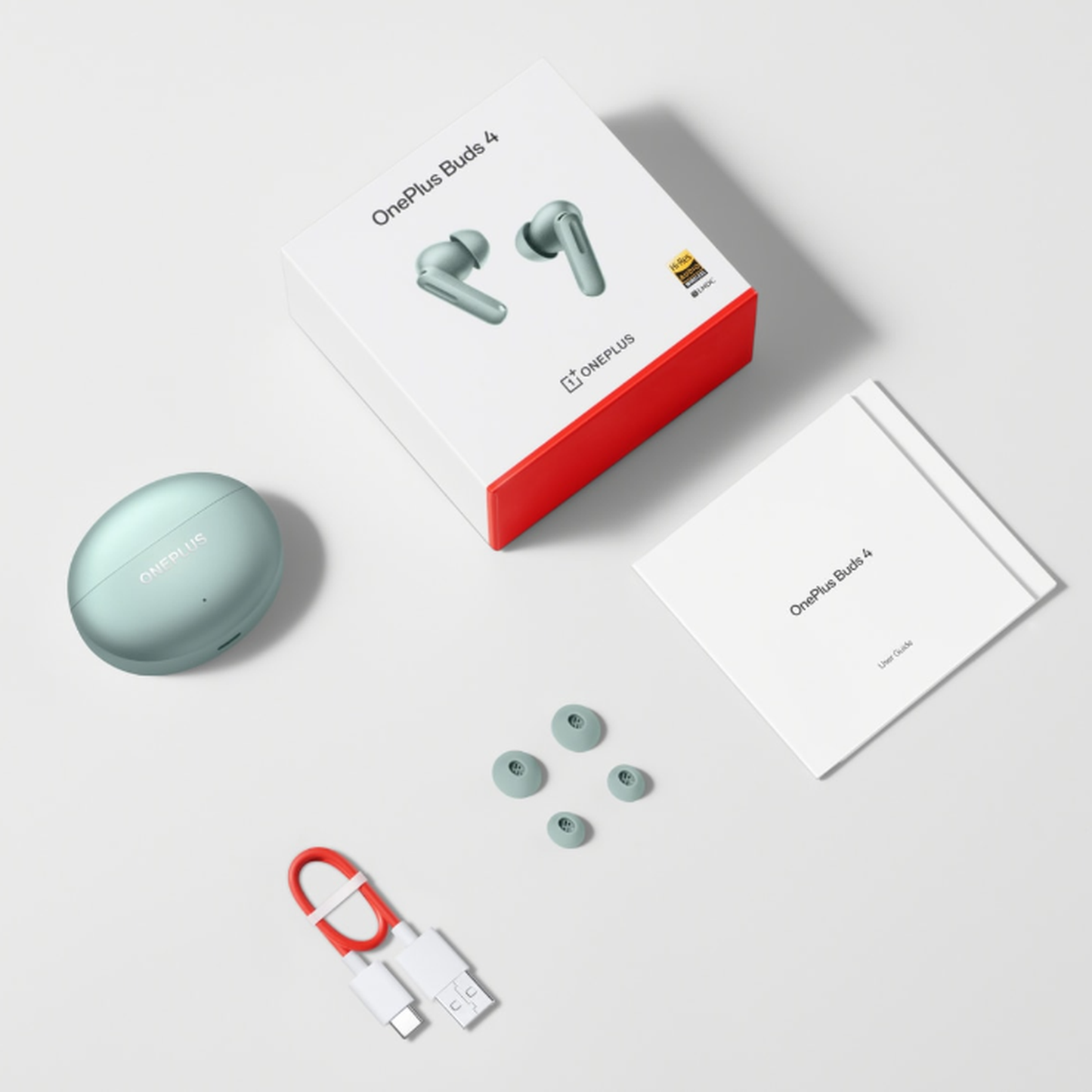 OnePlus Buds 4 Green complete in-box contents including earbuds, charging case, USB-C cable, ear tips, and user guide